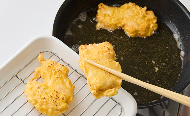 揚げ焼きした鶏肉を取り出している写真