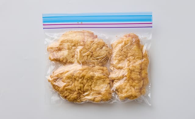 揚げ焼きした鶏肉を冷凍用保存袋に入れた写真