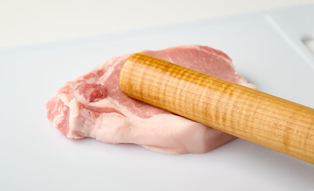 豚肉を叩いている写真
