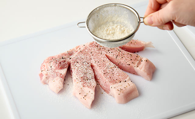 豚肉に小麦粉をふっている写真