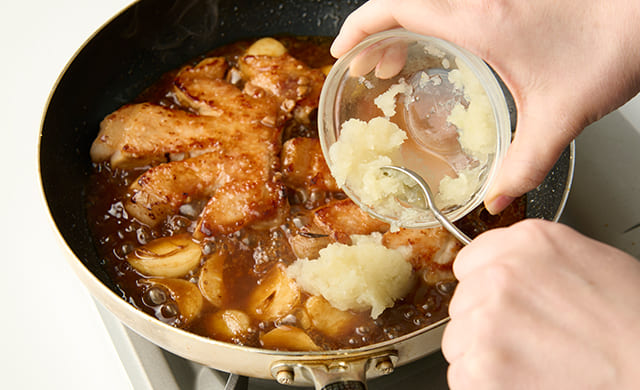 トンテキに玉ねぎを加えている写真