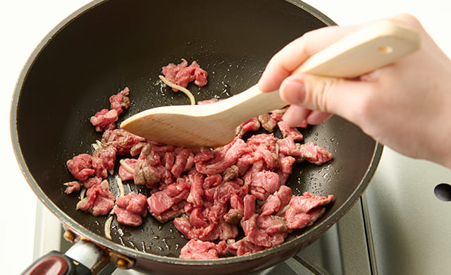牛肉を加えて炒めている写真