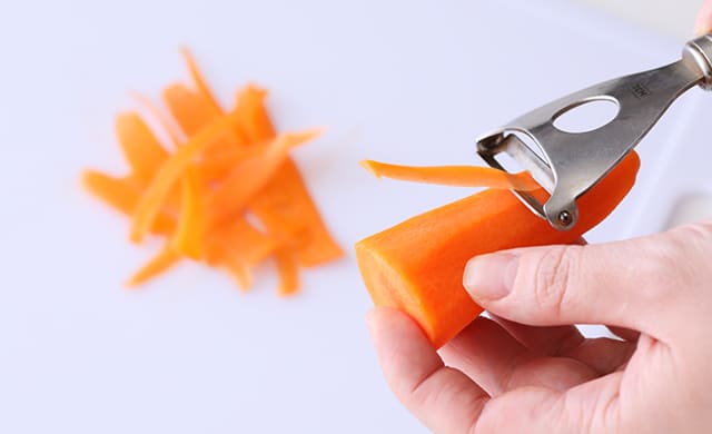 にんじんを薄いリボン状にスライスしている写真