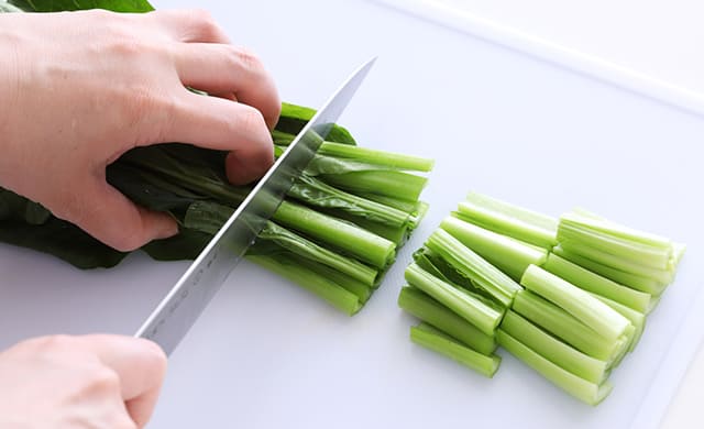 小松菜を3~4cm長さに切っている写真