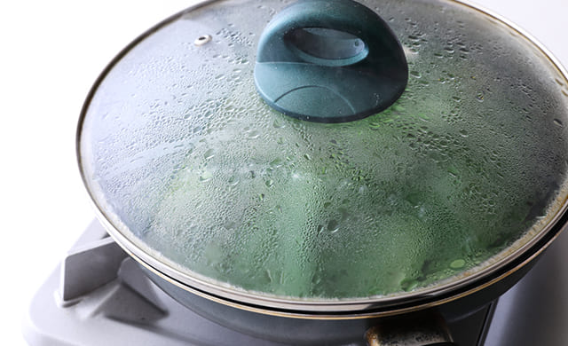 フライパンで野菜を蒸し煮にしている写真