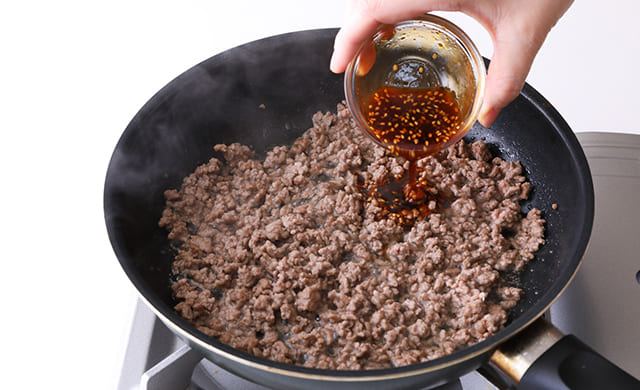 フライパンに焼き肉のたれを加えている写真