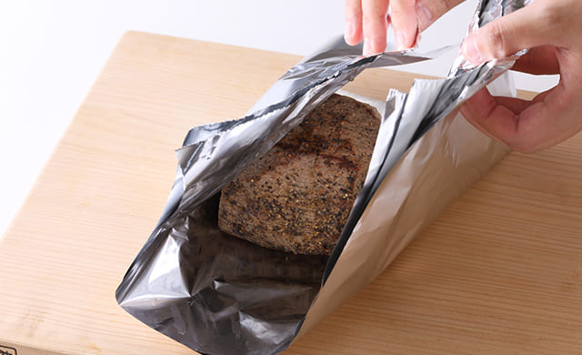 肉をアルミホイルで包んでいる写真