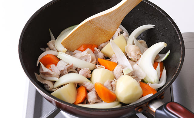 豚肉・玉ねぎ・にんじん・じゃがいもを炒めている写真