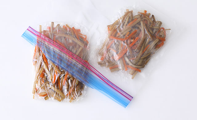 1食分(約40g)ずつラップで包んだきんぴらごぼうを冷凍用保存袋に入れる写真